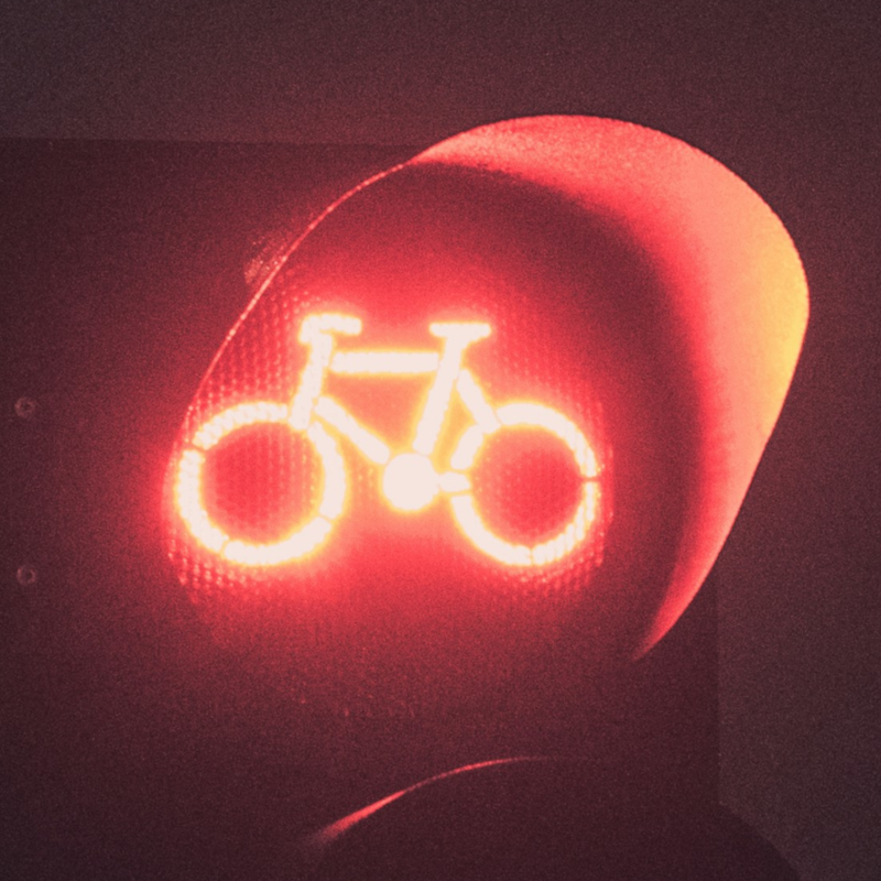 Rote Ampel für Radfahrer, der anhalten muss, Symbol für Stopp und Vorsicht im Straßenverkehr.