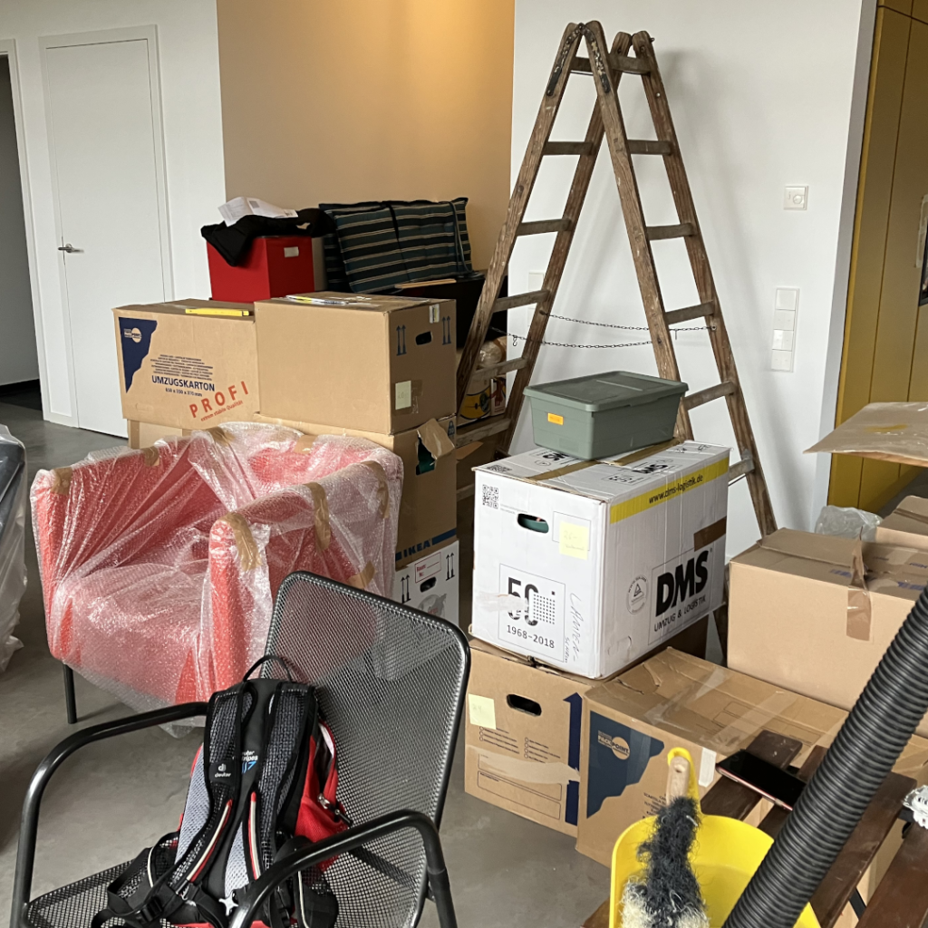 Chaotische, unaufgeräumte Wohnung mit herumstehenden Kartons und Gegenständen als Sinnbild für fehlende innere Ordnung