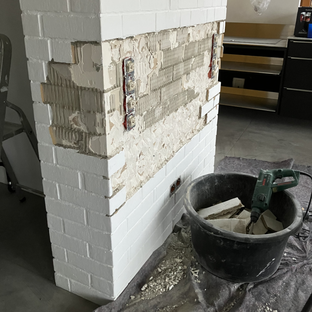 Echtes Leben: Abgeschlagener Putz an einer Innenwand während Renovierungsarbeiten mit sichtbarer Baustelle.