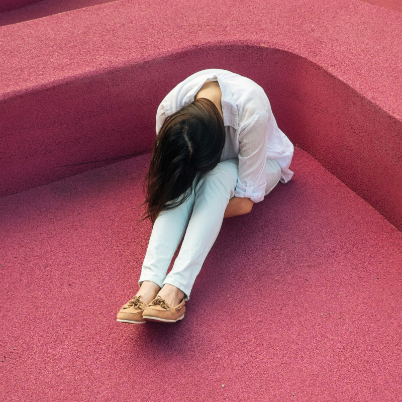 Erschöpftes Ego?! Frau sitzt kraftlos da und wirkt mental ausgelaugt.