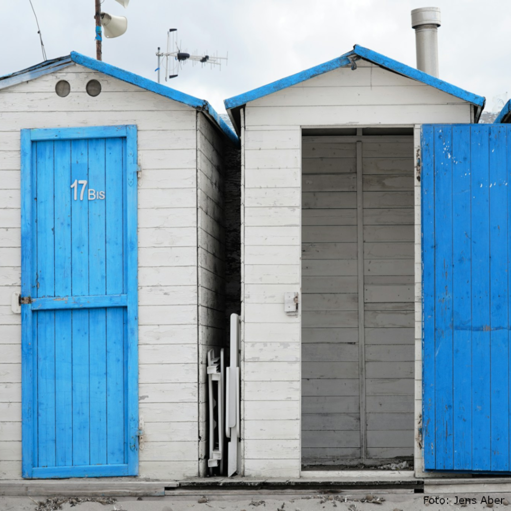 Strandkabinen mit offener und geschlossener Tür symbolisieren Entscheidungen zwischen Offenhalten und Commitment