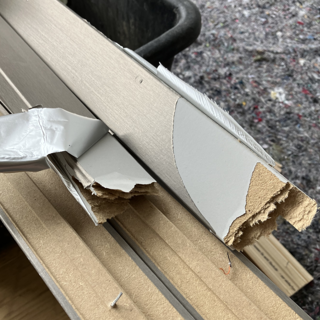 Mehr Schein: Alte Fußbodenleisten mit abgezogener Metallfolie, darunter beschädigtes Holz sichtbar